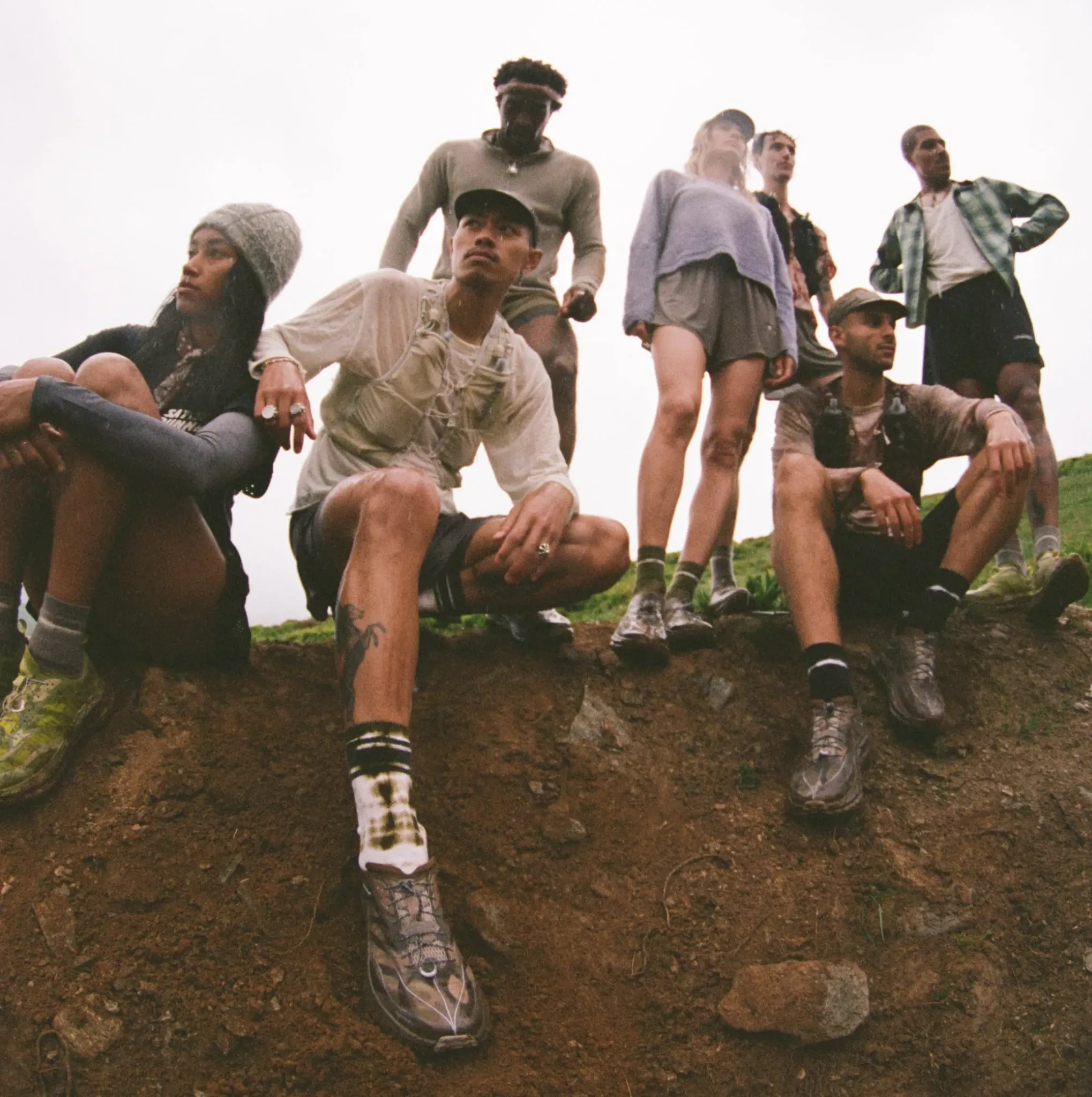 Runners in Satisfy × Hoka photography; the white-shirt runner’s face remains visible in this crop