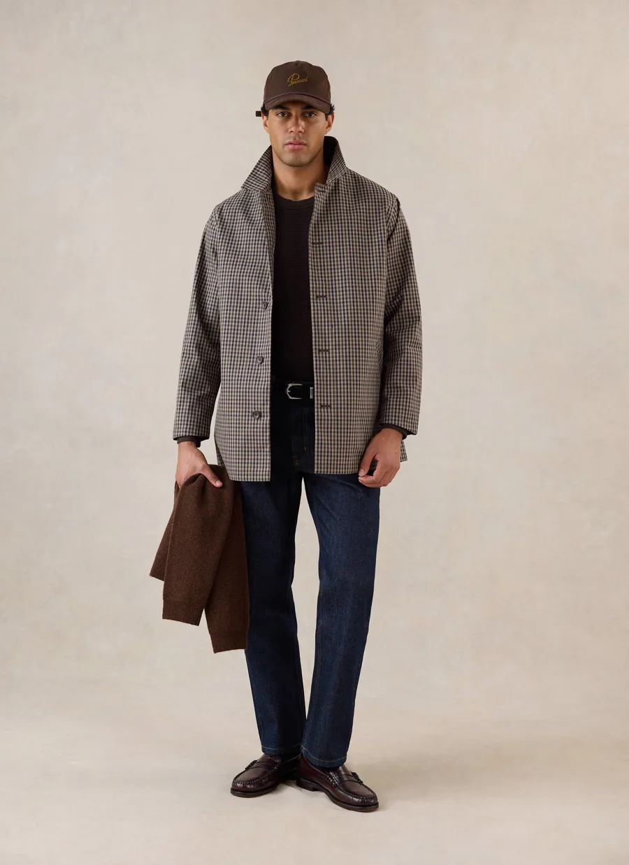 Man wearing Percival’s Sherlock Short Trench Coat in Watcher Check, with dark jeans