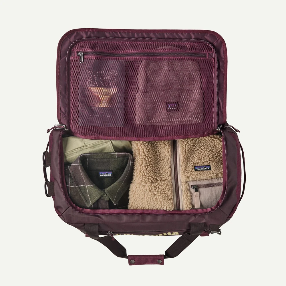 Open Patagonia Berry Fig duffel packed with a small selection of clothing.