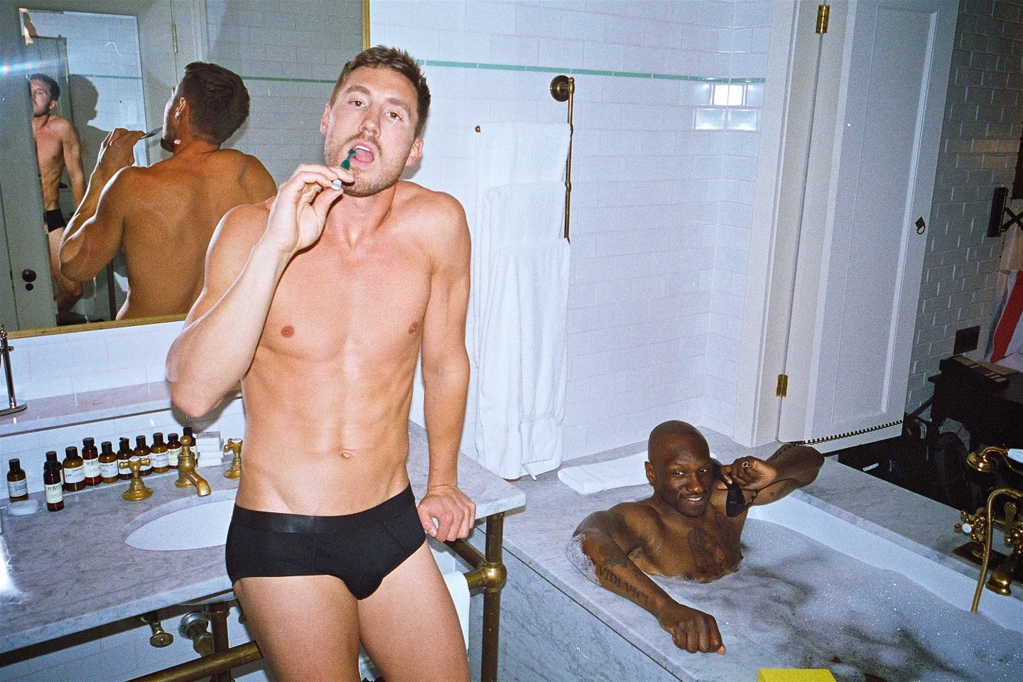 CDLP campaign photograph of adult men in a bathroom, one wearing black briefs.